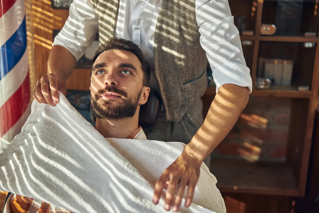 A barber finishing a client's cut