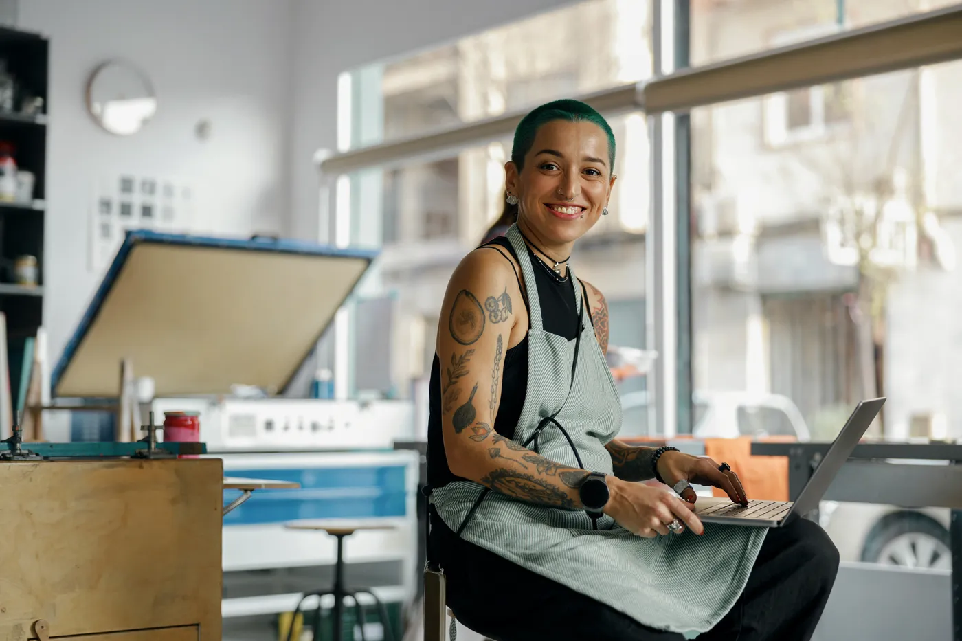 A studio owner at her front desk with her laptop open