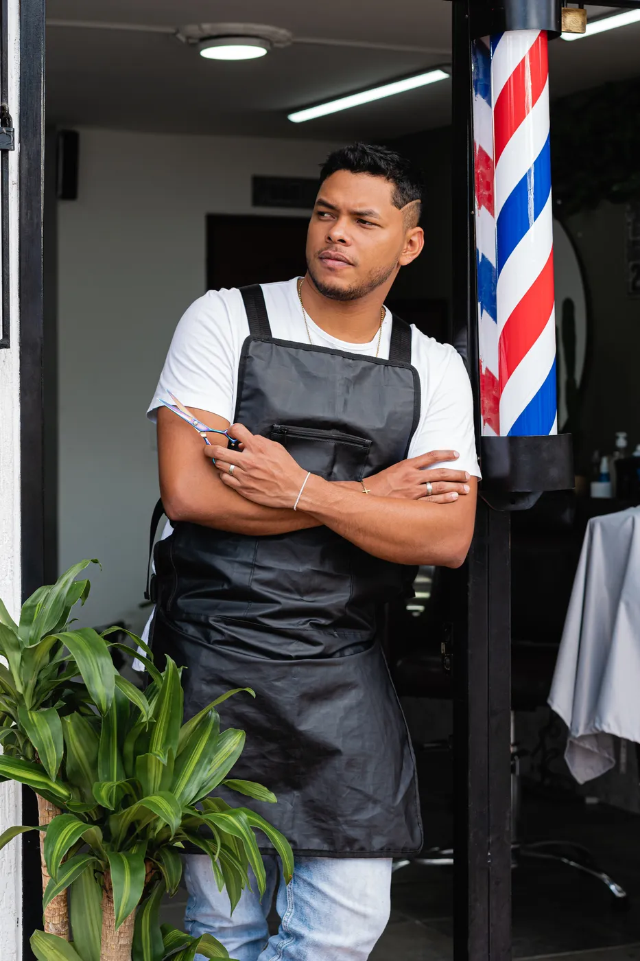 A barbershop owner standing at his shop door